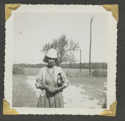 A woman standing on a dirt road