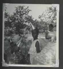 Four children wearing birthday hats and two adults
