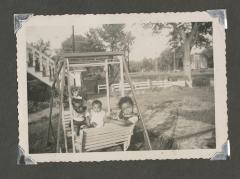 Three young children on a double swing set