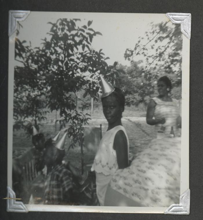 Four children wearing birthday hats and two adults