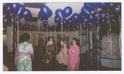 Women dancing in a room of balloons