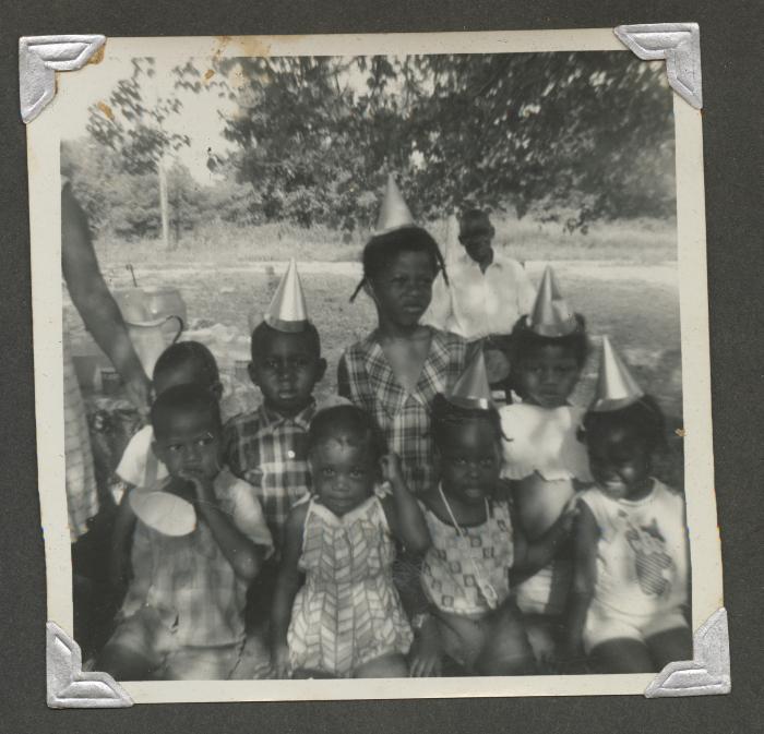 Eight children posing at a birthday celebration