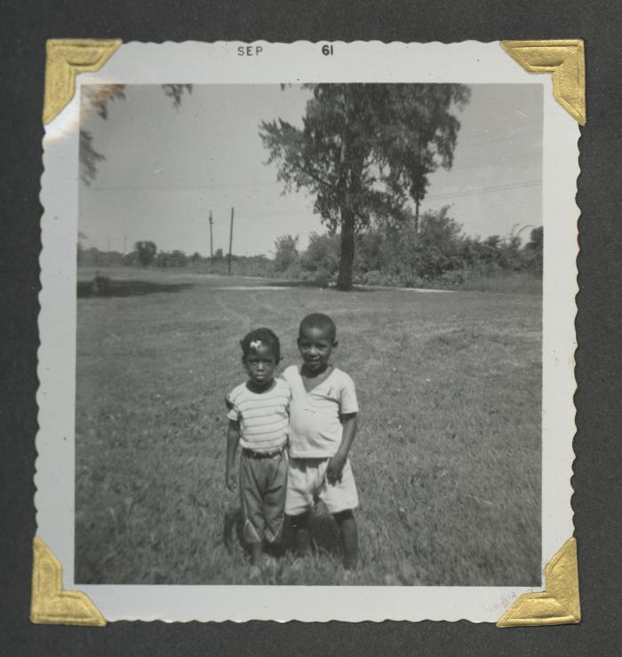 Two young children with their arms around the other