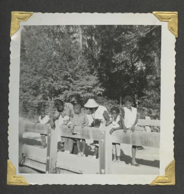 Eight people leaning on a railing