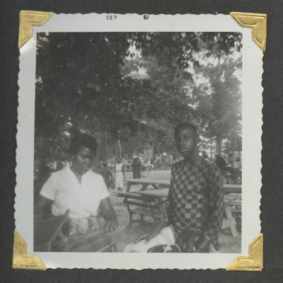 A young woman and man standing next to picnic tables