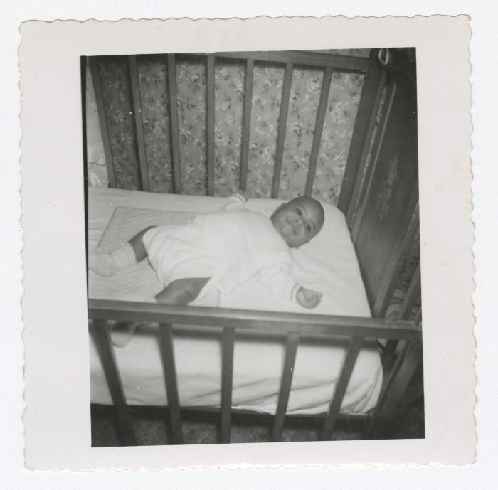 Baby laying on back in crib