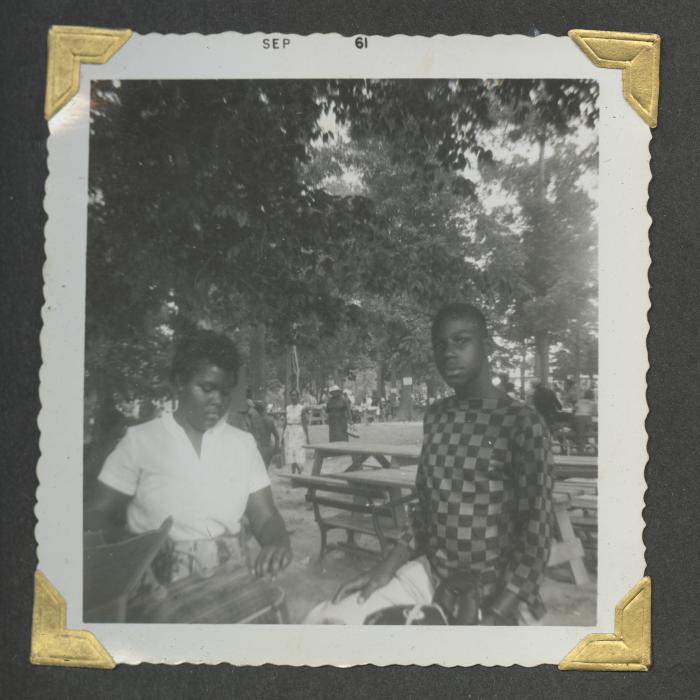 A young woman and man standing next to picnic tables
