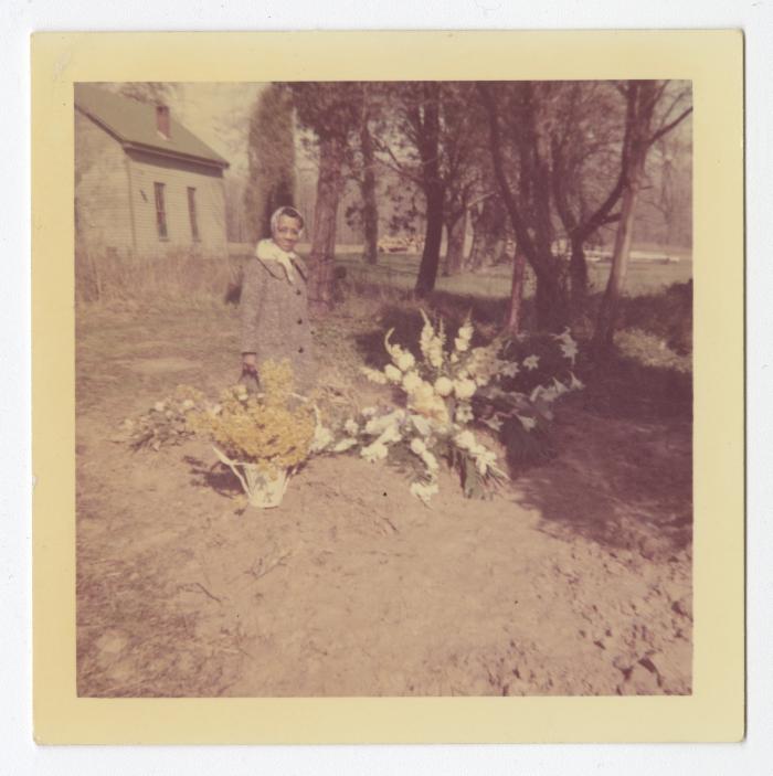 A woman standing next to yellow and white flowers
