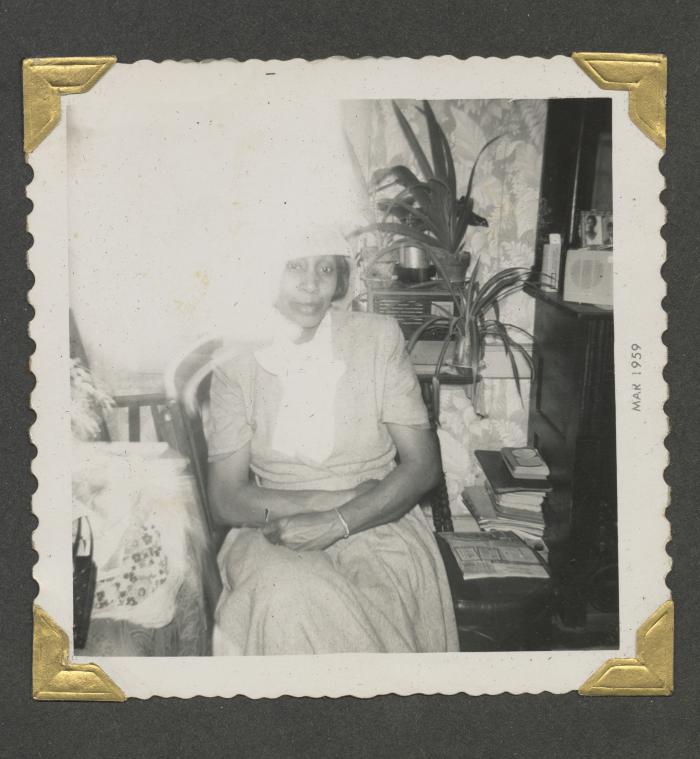 A woman sitting among plants and books