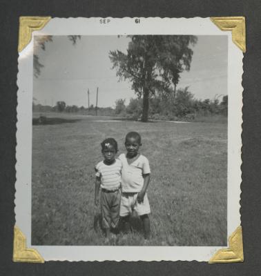 Two young children with their arms around the other