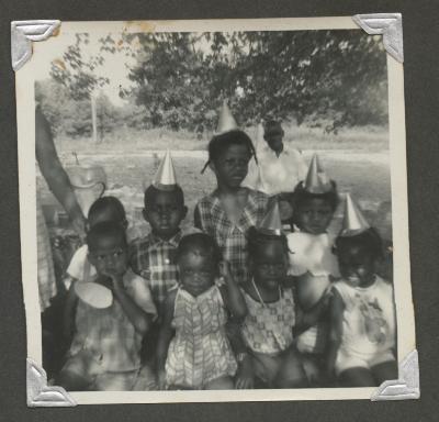 Eight children posing at a birthday celebration
