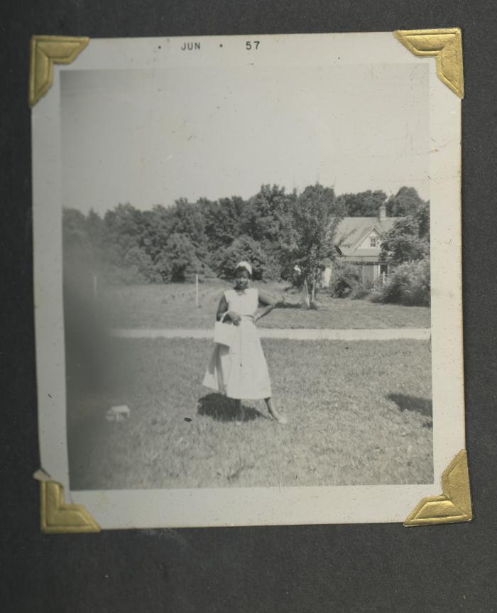 A woman with a white purse posing outside