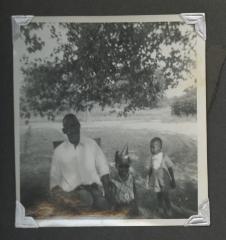 An older man sitting outside with two children