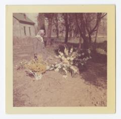 A woman looking at flowers on a grave