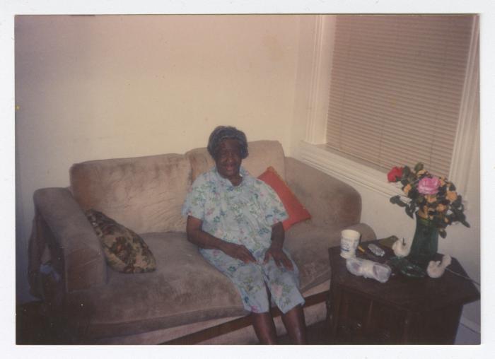 An older woman smiling on a couch