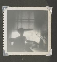 Shadowy image of a woman by an open window