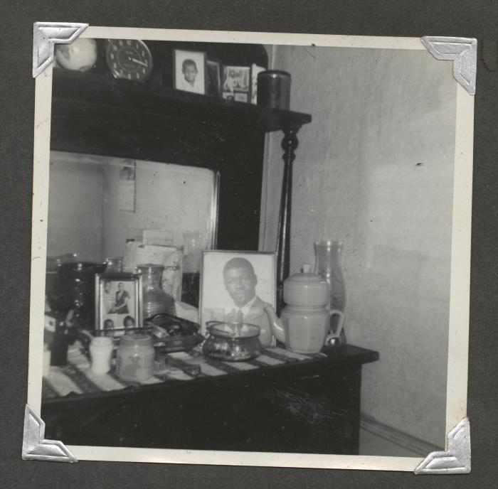A shelved bureau of trinkets and pictures