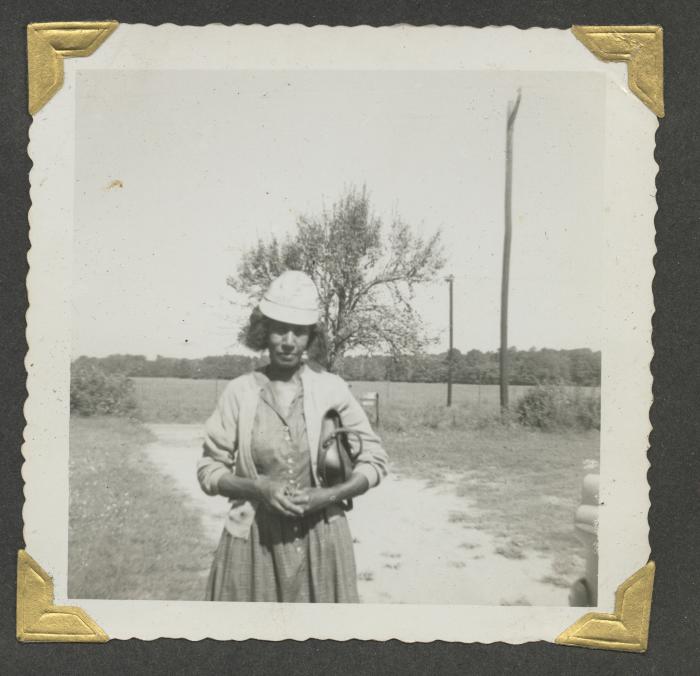 A woman standing on a dirt road