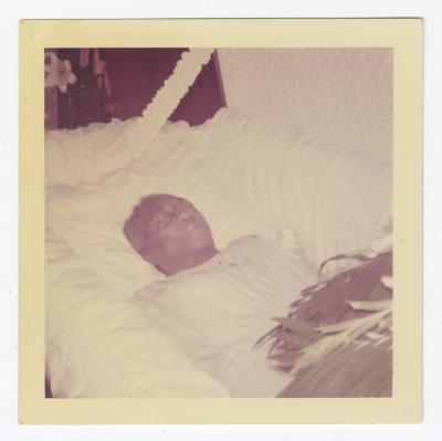 A deceased man in an open casket