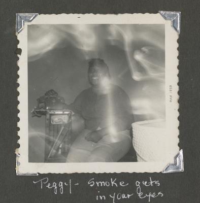 Peggy sitting in a smoky room