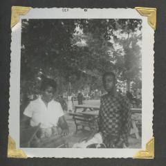 A young woman and man standing next to picnic tables