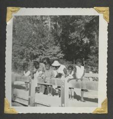 Eight people leaning on a railing