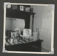 A shelved bureau of trinkets and pictures