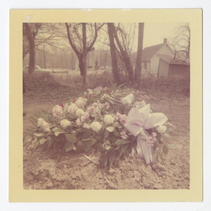 A white flowered wreath on a grave