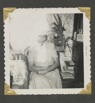 A woman sitting among plants and books