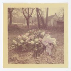 A white flowered wreath on a grave