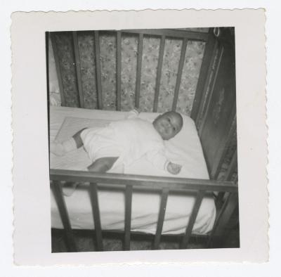 Baby laying on back in crib