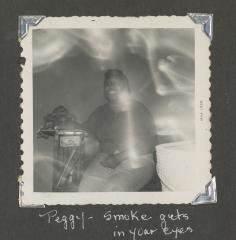 Peggy sitting in a smoky room