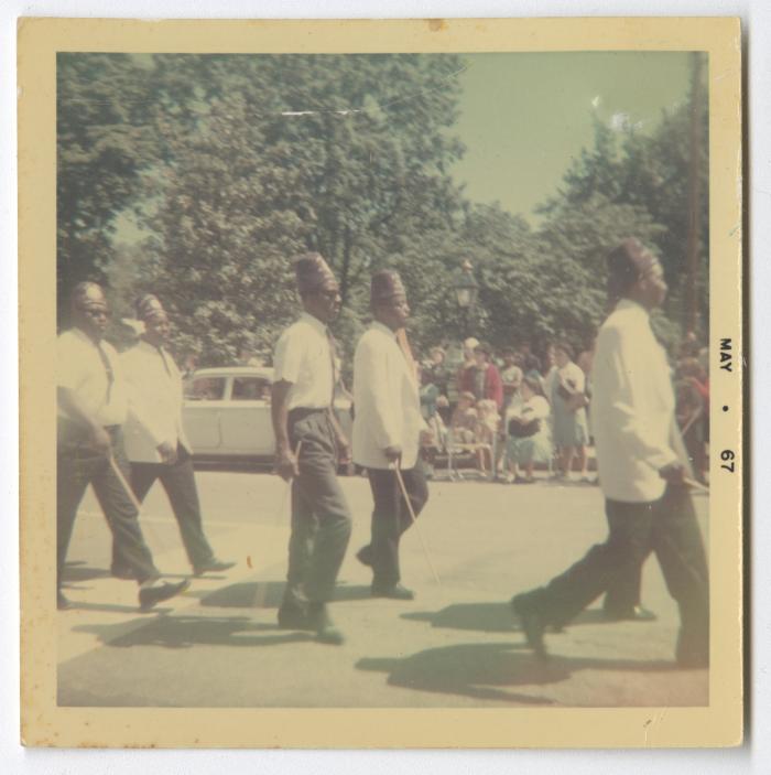 Men carrying sticks and marching