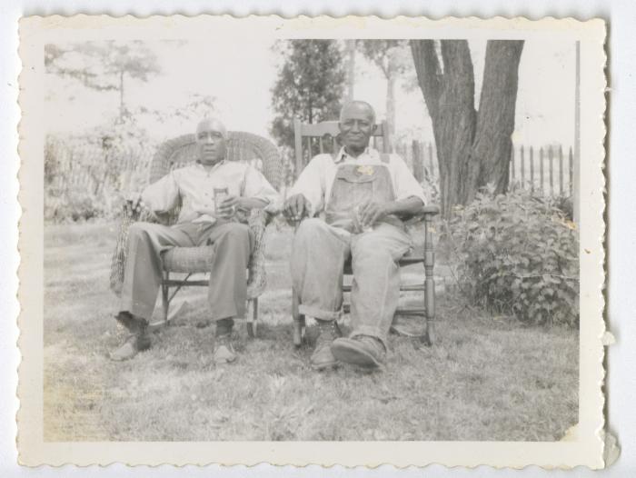 Two older men in chairs outside