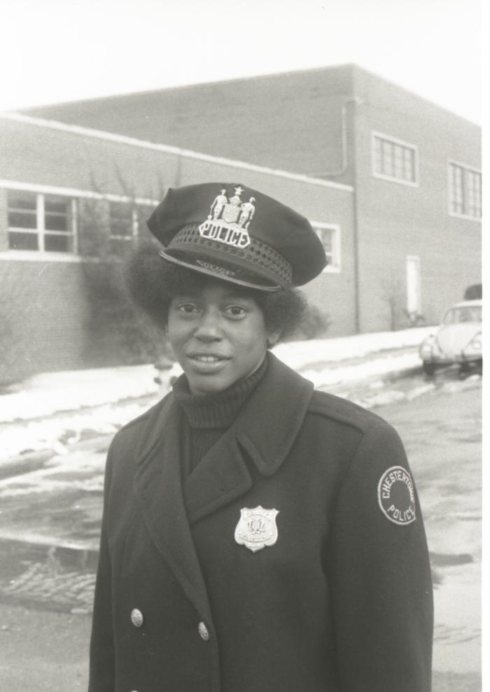 Unidentified African American female police officer acting as a crossing guard for Garnet School