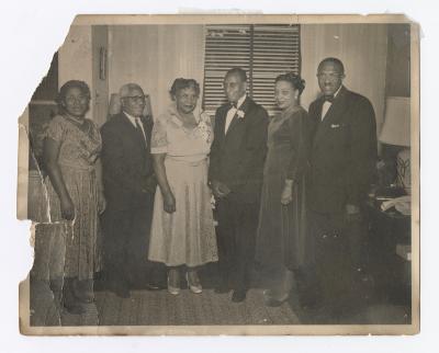 Six dressed up people standing together