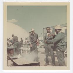 Sam Wright, two unknown men, Leon Reese, and Caramel Jones preparing food for a cookout at VITA Foods