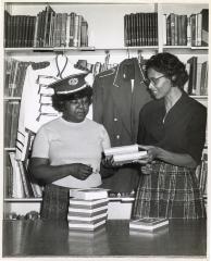 Amanda Frisby Bessick and Gertrude Reid sorting through books