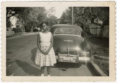Girl posing in front of an automobile