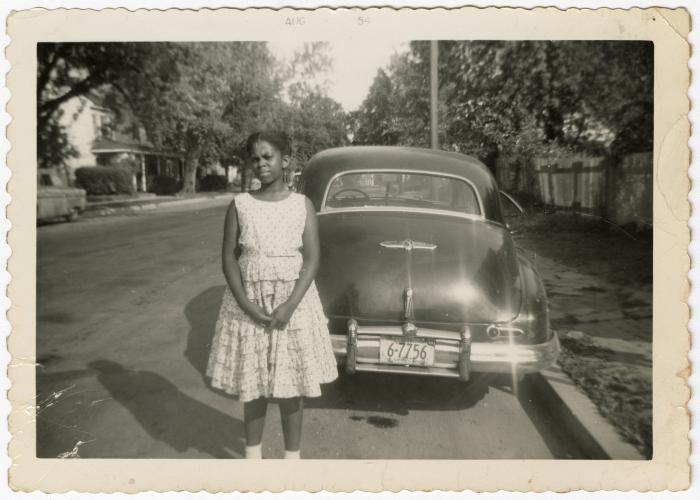 Girl posing in front of an automobile