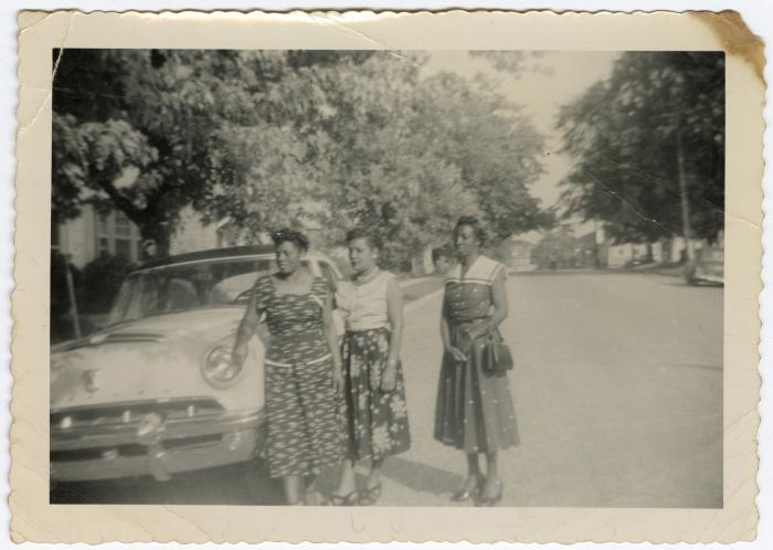 Women standing near an automobile on Calvert Street