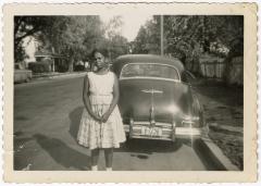 Girl posing in front of an automobile