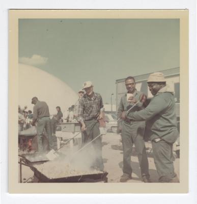 Sam Wright, two unknown men, Leon Reese, and Caramel Jones preparing food for a cookout at VITA Foods