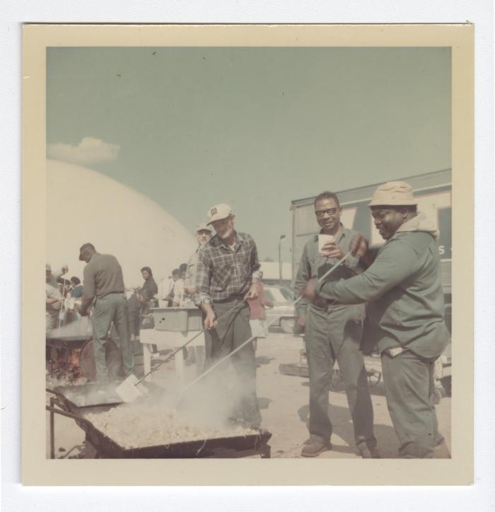 Sam Wright, two unknown men, Leon Reese, and Caramel Jones preparing food for a cookout at VITA Foods