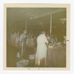 Women working in the fish department at VITA Foods. Sydney Caulk is standing beside the tubs of fish.