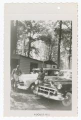 Jimmy Manuel and Sam Ringgold posing with cars at Sparrow's Beach
