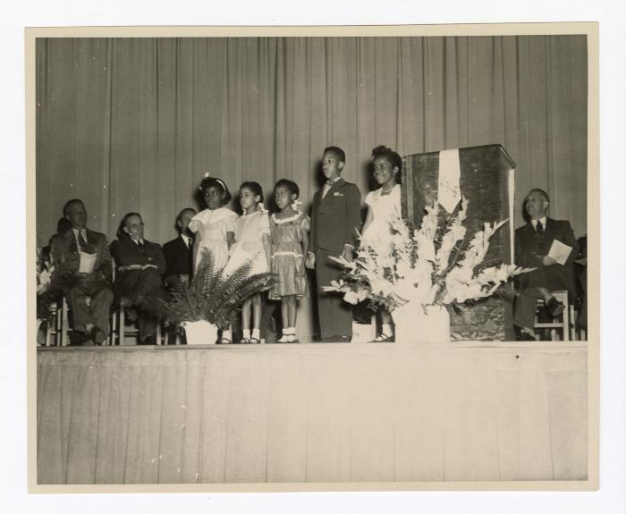 Children on stage performing at the Garnet School opening ceremony