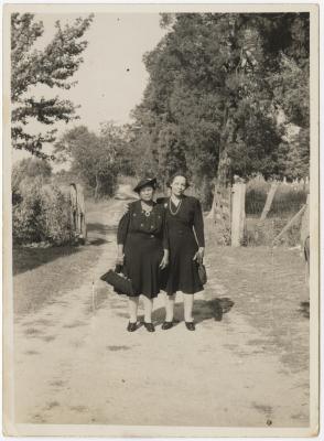 Two women outside cemetery 