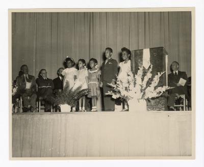 Children on stage performing at the Garnet School opening ceremony