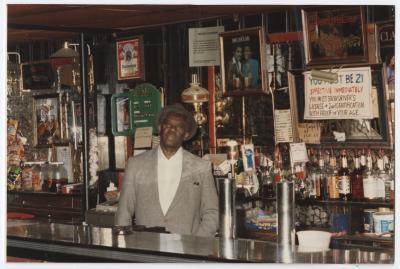 Charlie Graves behind bar at his Uptown Club, prior to demolition day, 1988